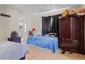 Bedroom featuring tile floors, a dark wood wardrobe, and a blue bedspread at 1828 Matterhorn Dr, Orlando, FL 32818