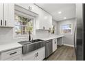 Bright kitchen with white cabinets, stainless steel appliances, and a farmhouse sink, perfect for modern living at 2014 10Th Nw St, Winter Haven, FL 33881