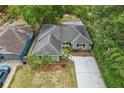 Aerial view of a home with a gray roof, mature trees, a driveway, and lush landscaping at 3204 Amherst Ave, Orlando, FL 32804