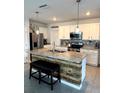 Open kitchen with an island, granite countertops, stainless steel appliances, and ample storage space at 321 Jovana Rd, Davenport, FL 33837