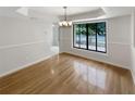 Bright dining room featuring a large window, hardwood floors, and modern lighting fixture at 4993 Heatherstone Pl, Orlando, FL 32812