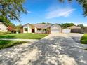 Charming single-story home with manicured lawn, and two-car garage on a sunny day at 4993 Heatherstone Pl, Orlando, FL 32812