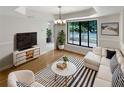 Bright living room featuring a large window, hardwood floors, and stylish modern furniture at 4993 Heatherstone Pl, Orlando, FL 32812