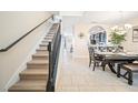 Open-concept dining area with a staircase, tile flooring, and modern lighting at 5156 Oakbourne Ave, Davenport, FL 33837