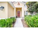 Inviting front entry with a covered porch, manicured plants, and stone accents at 5156 Oakbourne Ave, Davenport, FL 33837