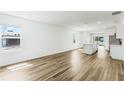Bright open-concept living area featuring wood-look flooring and natural light from large windows at 5258 Scrub Mint, Apopka, FL 32712