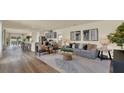 Open-concept living room with modern furniture, stylish decor, and seamless flow into the kitchen at 5282 Scrub Mint Ln, Apopka, FL 32712