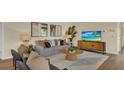 Cozy living room featuring a comfortable couch, modern TV, and stylish decorations on light wood floors at 5282 Scrub Mint Ln, Apopka, FL 32712