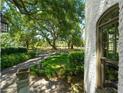 Lush greenery and mature trees surround this home, with a glimpse of a park through the arched window at 604 Cherokee Dr, Orlando, FL 32801