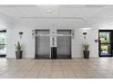 Building lobby with elevators, tile floor, plants, and decor at 6165 Carrier Dr # 1304, Orlando, FL 32819