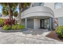 Inviting building entrance with palm trees, mature plants and covered entry at 6165 Carrier Dr # 1304, Orlando, FL 32819
