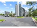Modern condo building with ample parking and well-maintained landscaping at 6165 Carrier Dr # 1304, Orlando, FL 32819