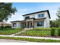 Stunning two-story modern home with manicured lawn and landscaped walkway leading to the front door at 705 N Lake Sybelia Dr, Maitland, FL 32751