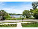 Beautiful view of the lake and dock from the property, enhanced by lush landscaping and a clear sky at 705 N Lake Sybelia Dr, Maitland, FL 32751