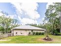 Well-maintained home featuring a metal roof, small garden, and green lawn at 723 River Run Rd, Osteen, FL 32764