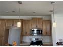 Bright kitchen featuring stainless steel appliances, quartz countertops, and elegant pendant lighting at 741 Spring Palms Loop, Orlando, FL 32828