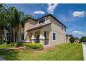 Attractive exterior view highlighting well-manicured lawn, tropical palms and welcoming covered porch at 7931 Rock Dove Dr, Winter Garden, FL 34787