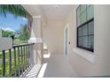 A covered front porch with white columns, rod iron railings, and a freshly painted concrete floor at 7931 Rock Dove Dr, Winter Garden, FL 34787