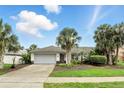 Inviting single-story home featuring a lush front yard, mature palms, and a convenient two-car garage at 826 Bright Meadow Dr, Lake Mary, FL 32746