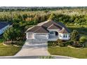 Well-maintained home featuring a three-car garage and a manicured lawn at 871 Iron Oak Way, The Villages, FL 32163