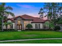 Beautiful home with lush green lawn, stone accents, and a tile roof at sunset at 914 Sweetgum Valley Pl, Lake Mary, FL 32746