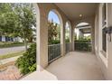 Inviting front porch with stylish arches and white railing, perfect for relaxing outdoors at 9567 Meadow Hunt Way, Winter Garden, FL 34787