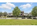 Street view of modern townhouses with landscaped front yards and a blue sky backdrop at 9820 Bucklow Hill Dr, Orlando, FL 32832