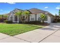 Gray single-Gathering home with well-maintained lawn, mature trees, and an attached two-car garage at 9885 Montclair Circle Cir, Apopka, FL 32703