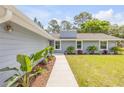 Landscaped walkway leading to the entrance of the beautifully maintained and updated single-story home at 106 Pine Tree Dr, Ormond Beach, FL 32174
