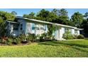 A charming home with a blue front door and shutters surrounded by lush green grass and well-maintained landscaping at 1118 Ne 17Th Ave, Ocala, FL 34470