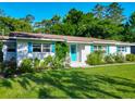 Inviting single story home with white brick, bright blue door and shutters, and beautiful flowerbeds in the landscaped yard at 1118 Ne 17Th Ave, Ocala, FL 34470