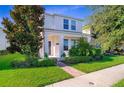 Charming two-story home with manicured lawn, bushes, front walkway, and a covered entryway supported by columns at 11386 Biography Way, Orlando, FL 32832
