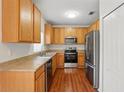 Efficient kitchen featuring stainless steel appliances, wooden cabinets, and laminate countertops at 13329 Harbor Shore Ln, Winter Garden, FL 34787