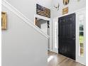 Elegant entryway featuring a modern black door, stylish decor, and wood-look flooring at 1555 Seminole Run Rd, Osteen, FL 32764