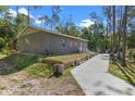 Exterior showcases the side of the home, concrete driveway, and lush green surroundings at 1611 Creekwood Run, Lakeland, FL 33809