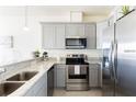 Well-equipped kitchen features gray cabinets, stainless steel appliances, and granite countertops at 1802 Coriander Dr, Kissimmee, FL 34759