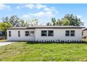 Charming single-story home featuring a white exterior, brick driveway, and well-maintained lawn at 2105 9Th Ne St, Winter Haven, FL 33880