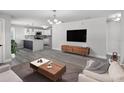 Bright living room showcasing wood floors, a modern coffee table, and an open floor plan to the kitchen at 2105 9Th Ne St, Winter Haven, FL 33880