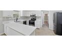 Charming kitchen featuring white cabinets, quartz countertops, and stainless steel appliances at 326 Evergreen Ct, Apopka, FL 32712