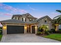 A luxury home boasts an expansive paver driveway leading to a three-car garage and gated courtyard at 3647 Farm Bell Pl, Lake Mary, FL 32746