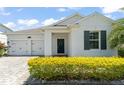 Inviting one-story home showcasing a well-kept lawn, front-entry two-car garage, and a decorative wreath on the front door at 4599 Storytelling Way, Kissimmee, FL 34746