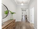 Hallway featuring wood floors, crown molding and view through to the living room with neutral decor at 4599 Storytelling Way, Kissimmee, FL 34746