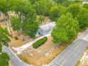 Aerial view of a quaint home with mature trees, a well-maintained lawn, and street access at 499 W Beresford Rd, Deland, FL 32720