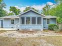 Exterior showing light blue siding, a screened porch with white trim, and a well-kept yard at 499 W Beresford Rd, Deland, FL 32720