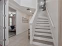 Welcoming entryway with staircase featuring neutral tile floors and natural light at 7564 Marker Ave, Kissimmee, FL 34747