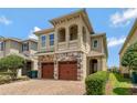 Charming two-story home showcasing a stone facade, a brick driveway, and a second story balcony at 7564 Marker Ave, Kissimmee, FL 34747