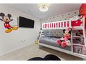Adorable bedroom featuring a bunk bed, cartoon character decor and tile floors at 7905 Golden Pond Cir, Kissimmee, FL 34747