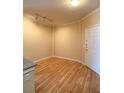 An empty room featuring wood floors, base trim, track lighting, and a door to the hallway at 860 N Orange Ave # 428, Orlando, FL 32801