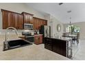 Spacious kitchen with dark wood cabinets, stainless steel appliances, and a functional center island at 1007 Golf View Estates Dr, Orange City, FL 32763