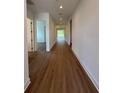 A long hallway with wood flooring leads to a bright, open space, freshly painted and ready for personal touches at 1043 Gloryland Ct, Sanford, FL 32771